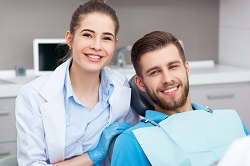 man smiling with female dentist, getting dental exam and teeth cleaning Monmouth Junction, NJ